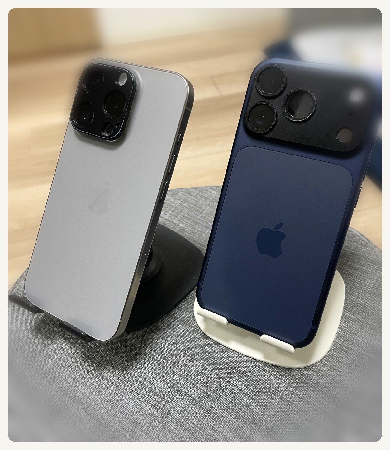 iPhone 15 ProとiPhone 17 Proをスタンドに立てて並べた写真。15 Proのチタンの側面が見える